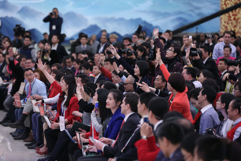 3月15日，國務院總理李克強在北京人民大會堂與中外記者見面，并回答記者提問。這是記者舉手爭取提問機會。 新華社記者 才揚 攝